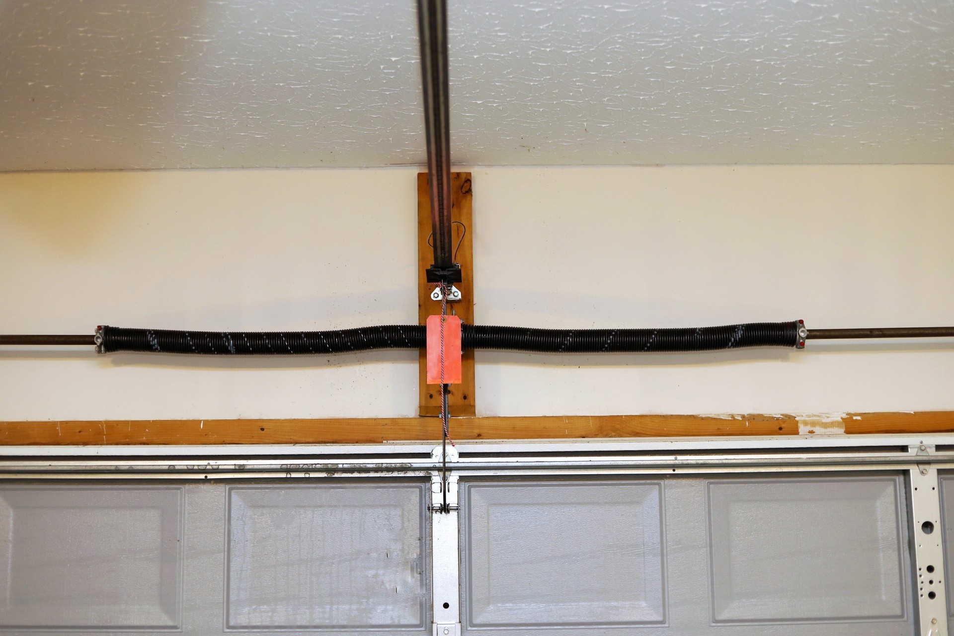 A close up image of a the springs on a overhead garage door opener